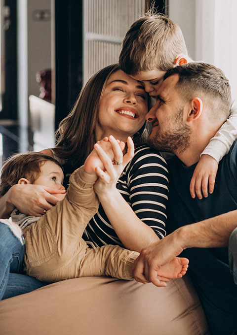 family of four sitting together smiling and enjoying each other's company celebrating love and joy during their 15 moments