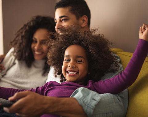 happy family enjoying time together on couch with joyful child celebrating playful moments at home